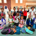 preschool class posing with their new backpacks